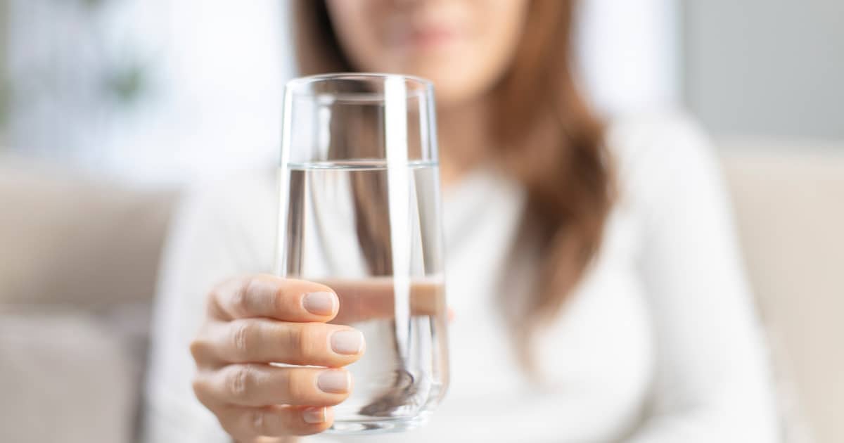 Frau hält ein Glas Wasser